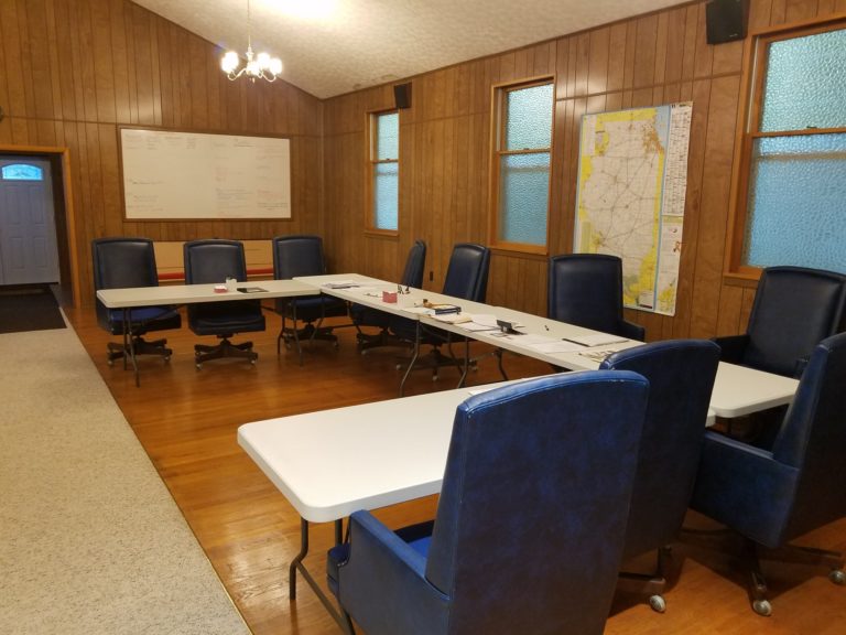 Village Hall meeting room with tables, chairs and a wall map