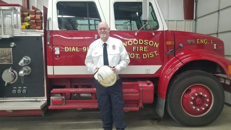 Firefighter standing in front of a Woodson Fire Protection District engine