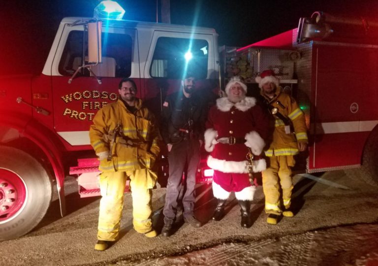 Santa with firefighters in front of a fire engine