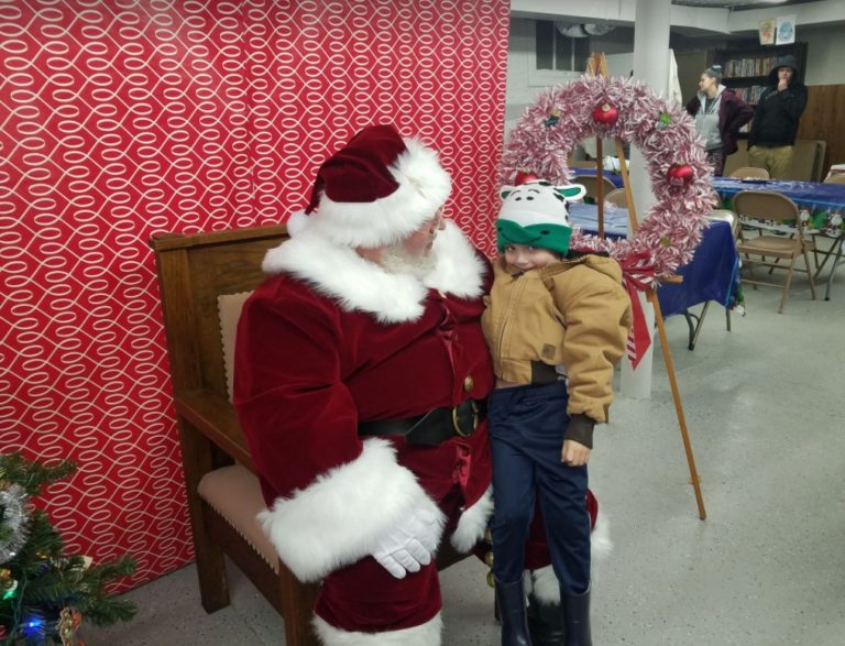 Santa Claus with a child in a green hat
