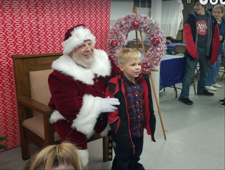 Santa Claus with a child at the village holiday event