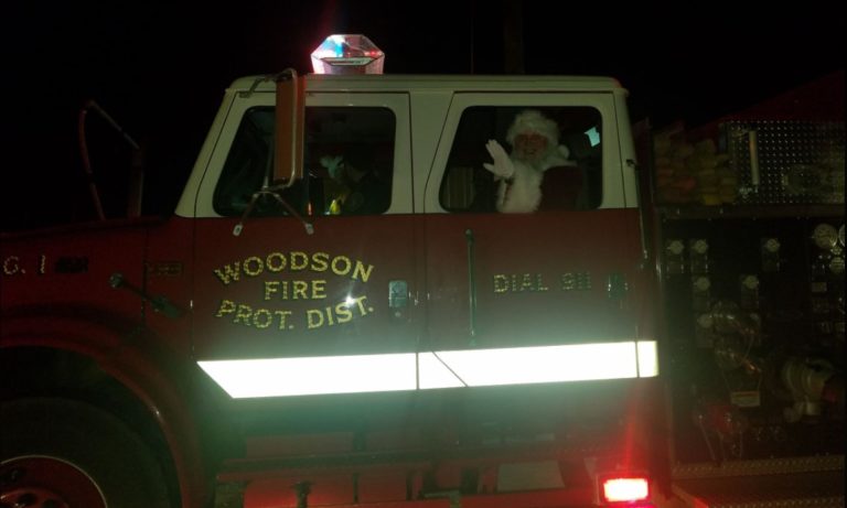 Santa waving from a Woodson fire engine at night