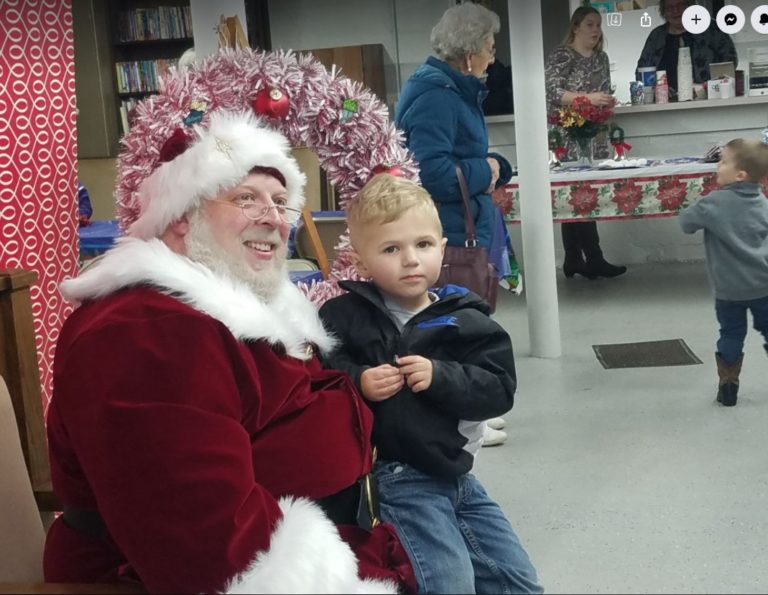 Santa Claus with a child at the village holiday event