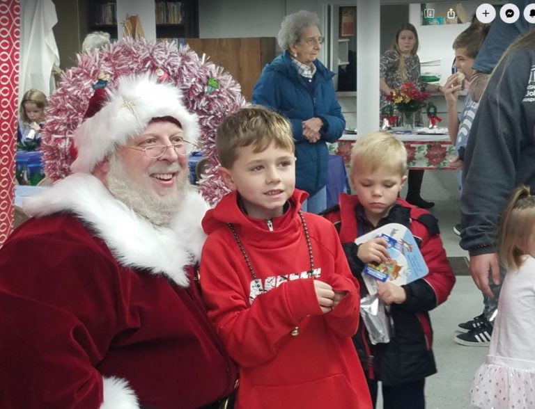 Santa Claus with two children at the village holiday event