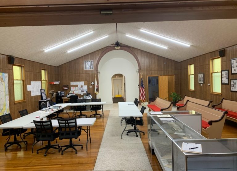 Renovated Village Hall meeting room with tables and display case