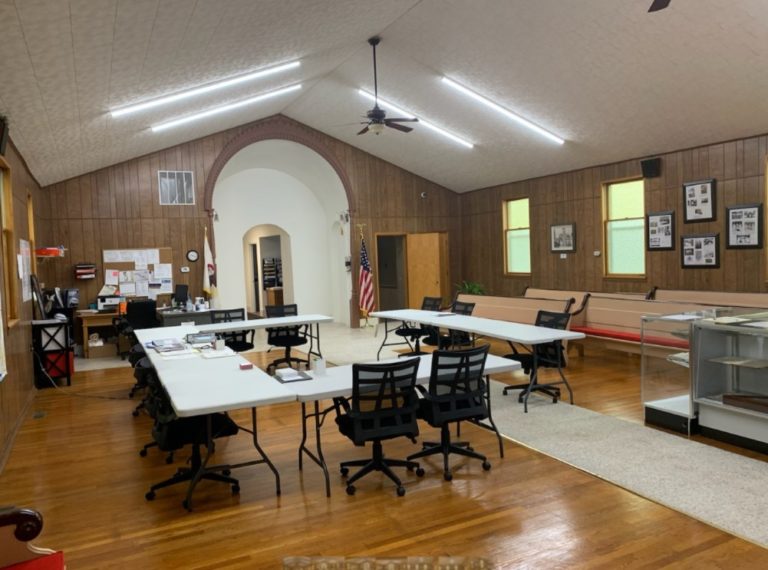 Village Hall meeting room with tables, chairs and framed photos