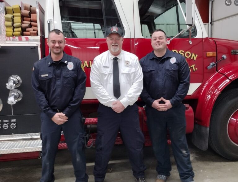 Three firefighters in front of a Woodson fire engine