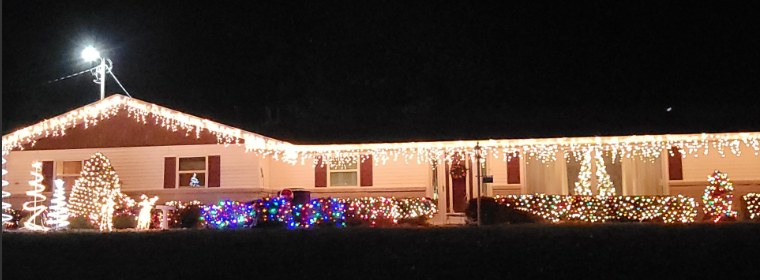 Ranch home outlined in white icicle lights at night