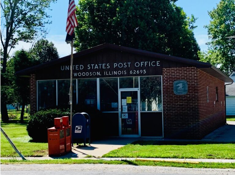 Woodson post office, a brick building with a flag and mailboxes out front